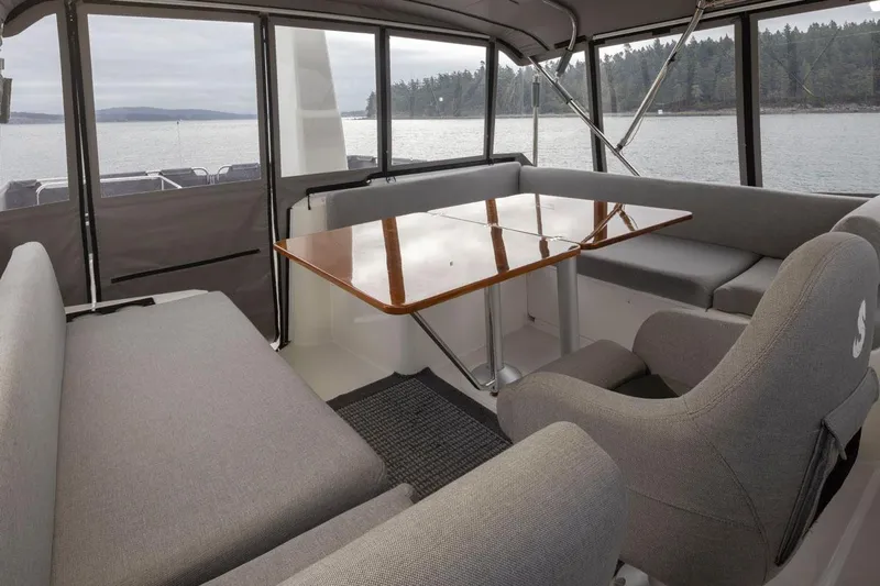 4 My Valentine Yacht Photos Pics Interior of 2022 Beneteau Swift Trawler 41 with seating and table, overlooking water.