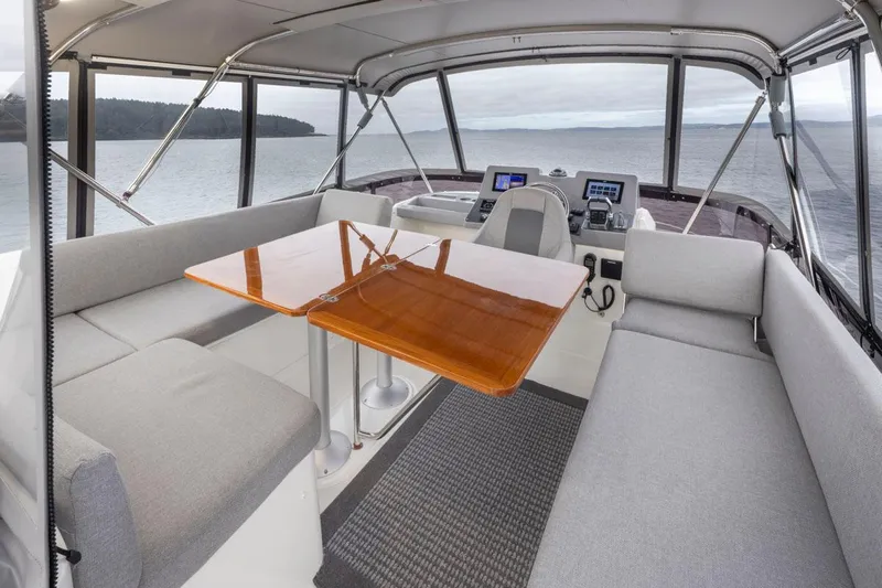 4 My Valentine Yacht Photos Pics Interior of 2022 Beneteau Swift Trawler 41 with seating and helm, overlooking water.