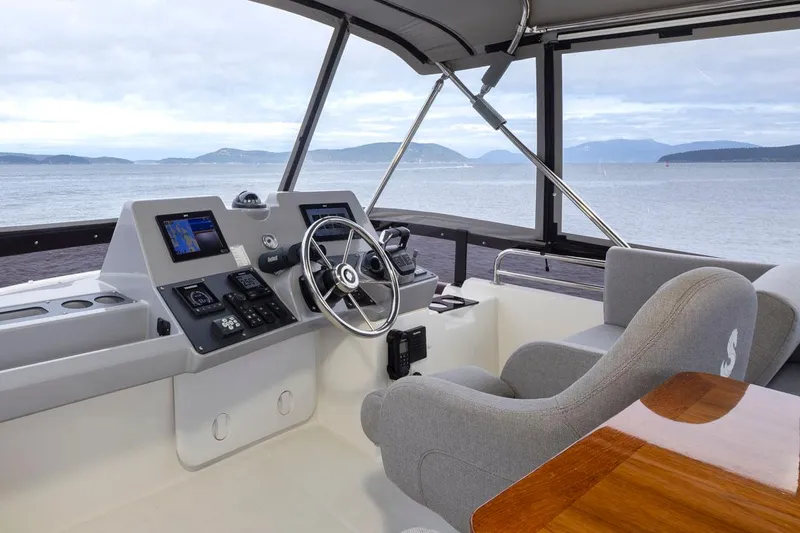 4 My Valentine Yacht Photos Pics 2022 Beneteau Swift Trawler 41 helm with ocean view, featuring modern navigation equipment.