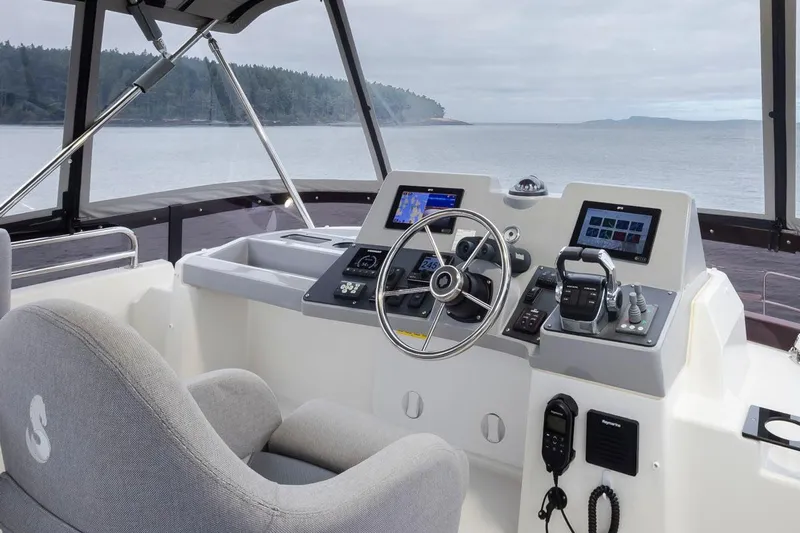 4 My Valentine Yacht Photos Pics 2022 Beneteau Swift Trawler 41 helm with modern navigation equipment and scenic ocean view.