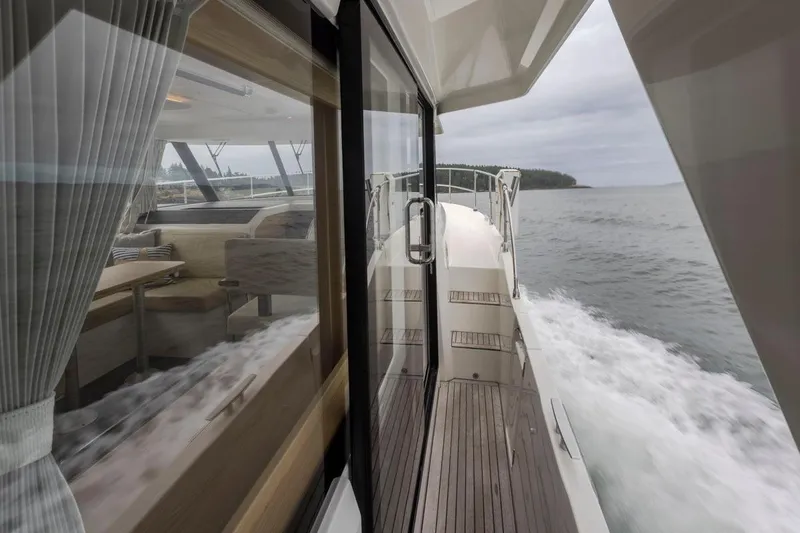 4 My Valentine Yacht Photos Pics 2022 Beneteau Swift Trawler 41 cruising on open water, interior view through glass.