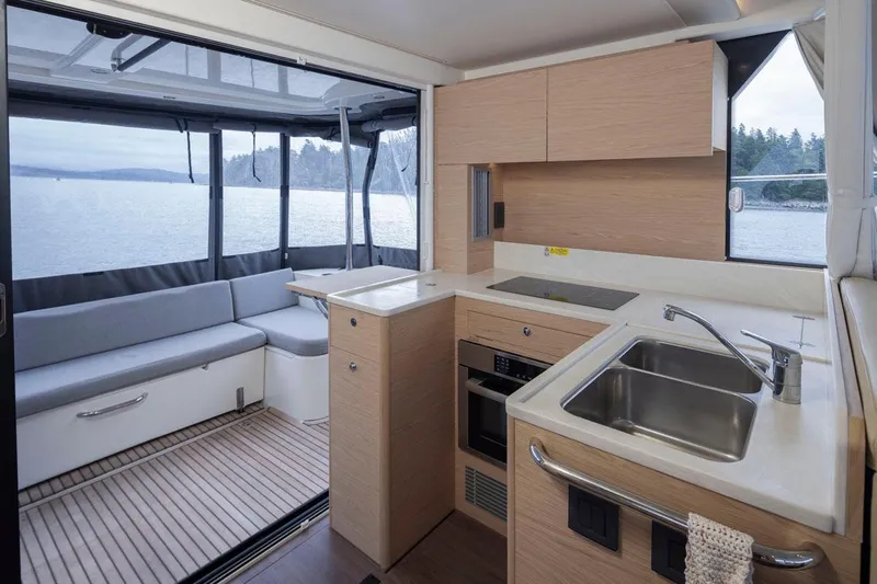 4 My Valentine Yacht Photos Pics Modern kitchen and seating area in 2022 Beneteau Swift Trawler 41, overlooking serene waters.