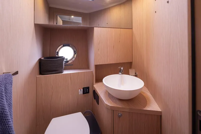 4 My Valentine Yacht Photos Pics 2022 Beneteau Swift Trawler 41 bathroom with modern sink and wooden cabinetry.