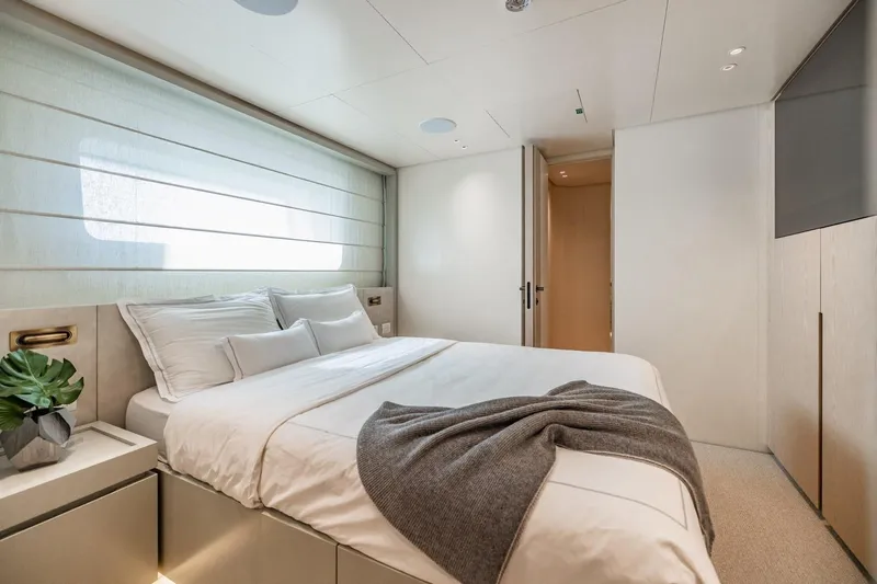 Legacy Yacht Photos Pics Luxurious bedroom interior of 2022 Sanlorenzo SD96 yacht, featuring elegant design and cozy bedding.