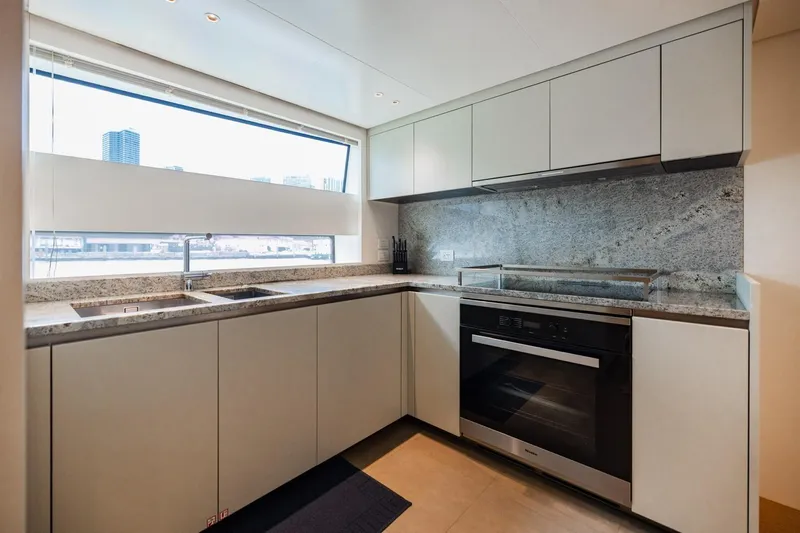 Legacy Yacht Photos Pics Modern kitchen in 2022 Sanlorenzo SD96 yacht with sleek cabinetry and granite countertops.