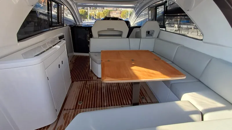  Yacht Photos Pics 2023 Beneteau Gran Turismo 41 interior with wooden table and white seating.