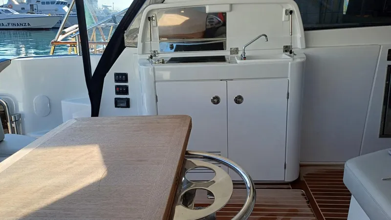  Yacht Photos Pics 2023 Beneteau Gran Turismo 41 yacht interior with kitchenette and wooden table.