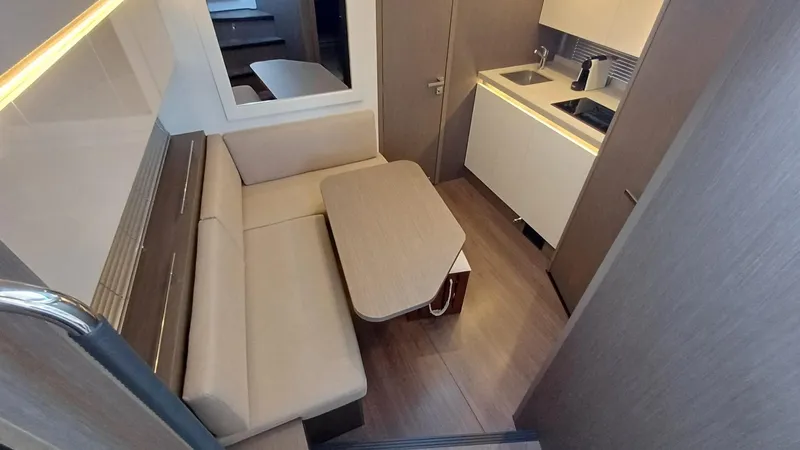  Yacht Photos Pics 2023 Beneteau Gran Turismo 41 interior with modern seating and compact kitchenette.