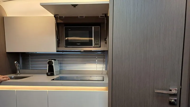  Yacht Photos Pics Modern kitchen interior of 2023 Beneteau Gran Turismo 41 yacht with microwave and coffee maker.