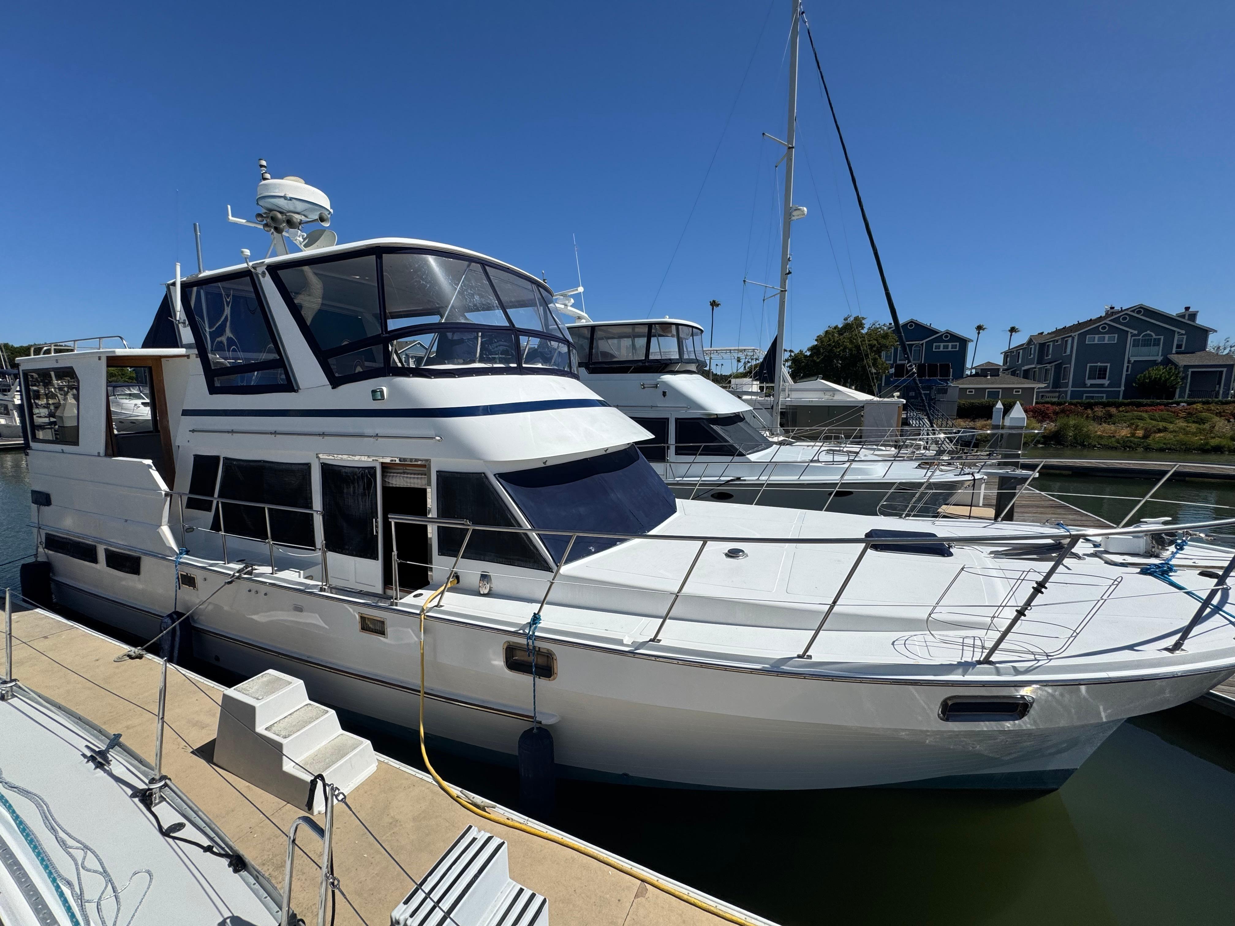 1990 Nova 48 yacht docked at marina under clear blue sky.