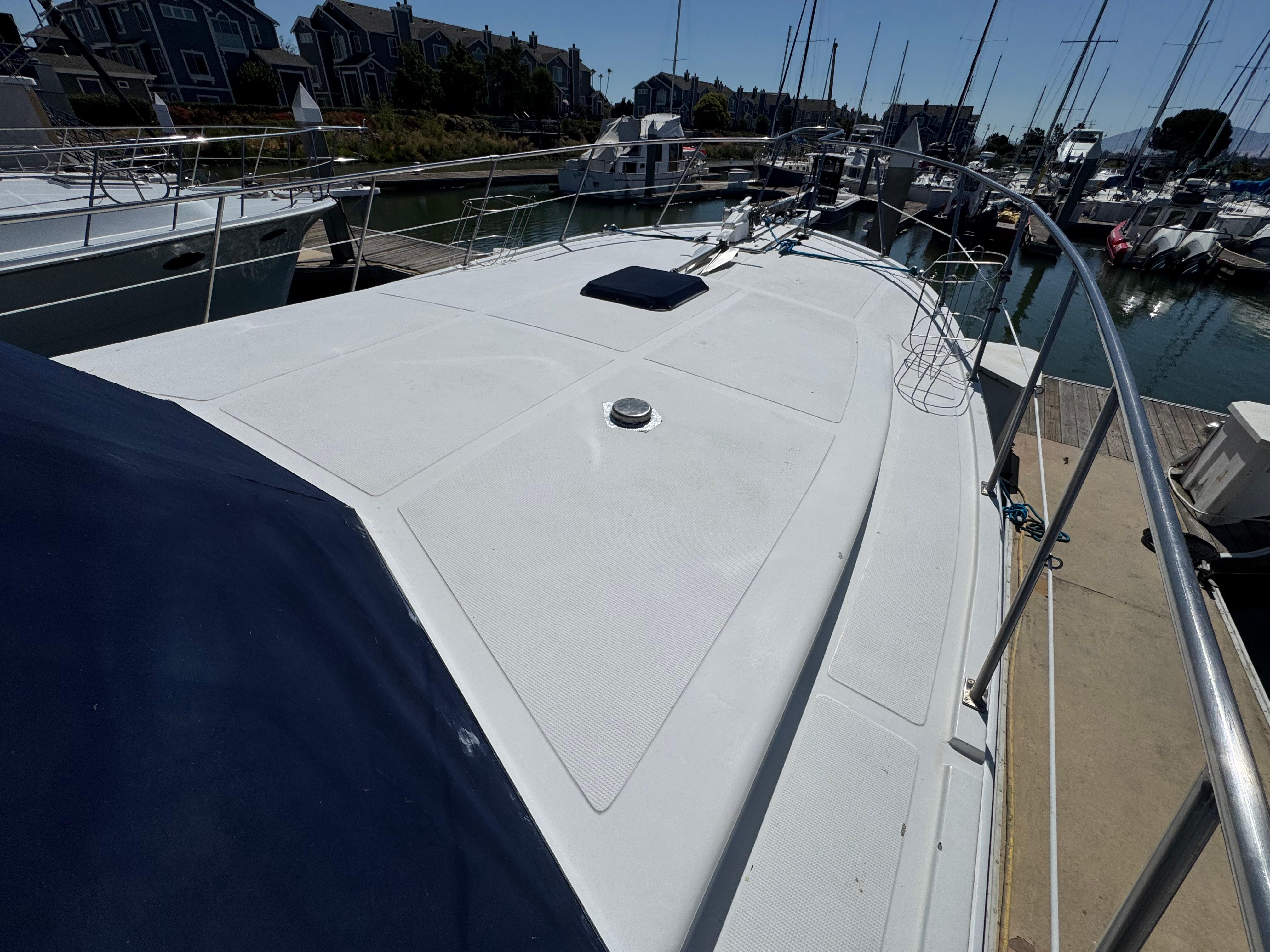 Deck of a 1990 Nova 48 yacht docked at a marina with sailboats.