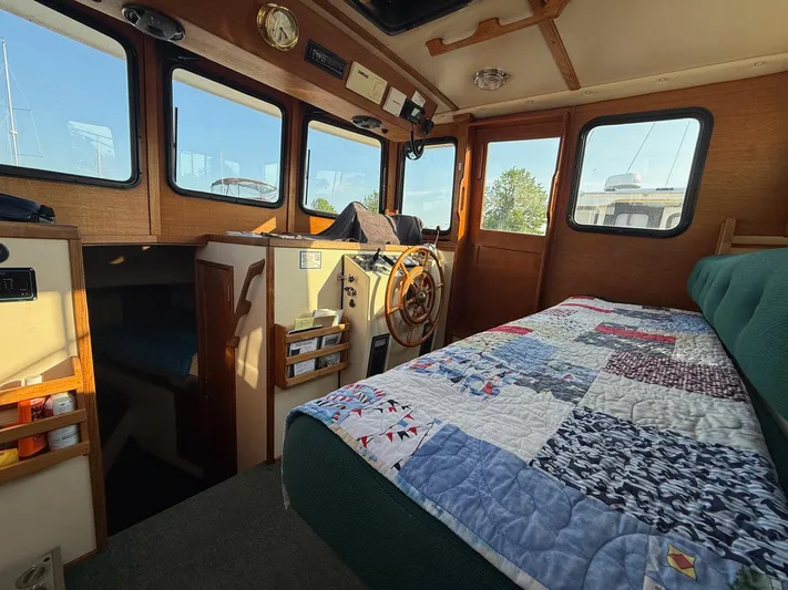 Emerald Isle Yacht Photos Pics Interior of a 1998 Nordic Tug Trawler with cozy cabin and quilted bedding.