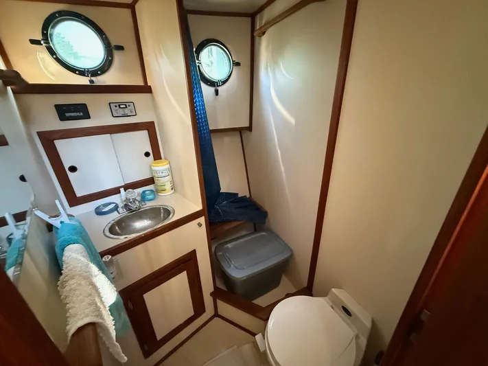 Emerald Isle Yacht Photos Pics Bathroom interior of a 1998 Nordic Tug Trawler with sink, toilet, and porthole windows.