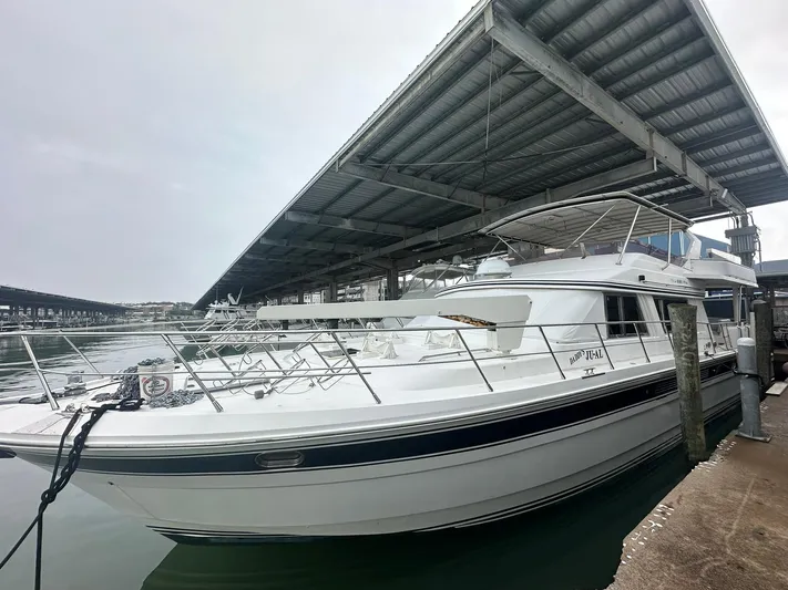 Daddy's Ju-al Yacht Photos Pics 1996 President 655 Flybridge Cockpit MY yacht docked under a covered marina.