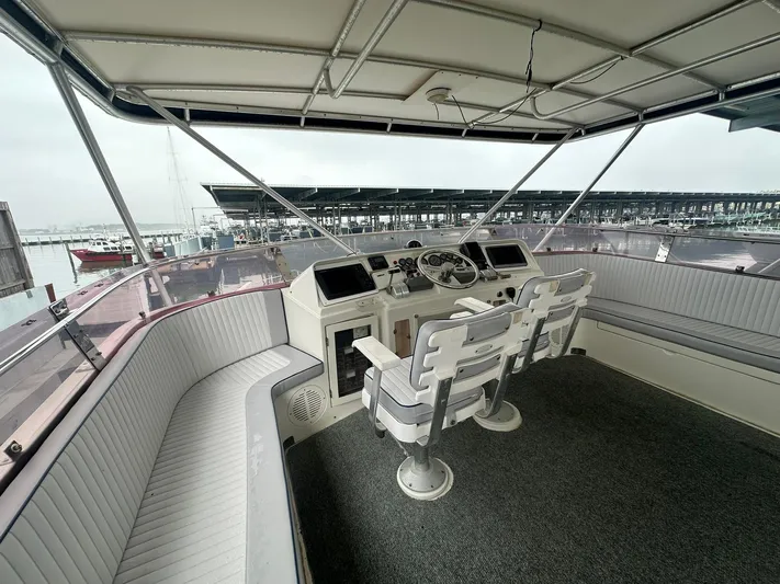 Daddy's Ju-al Yacht Photos Pics 1996 President 655 Flybridge Cockpit MY helm station with seating, overlooking marina.