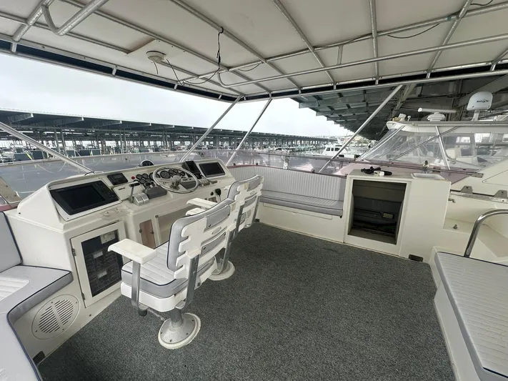 Daddy's Ju-al Yacht Photos Pics 1996 President 655 Flybridge Cockpit MY helm station with seating and marina view.