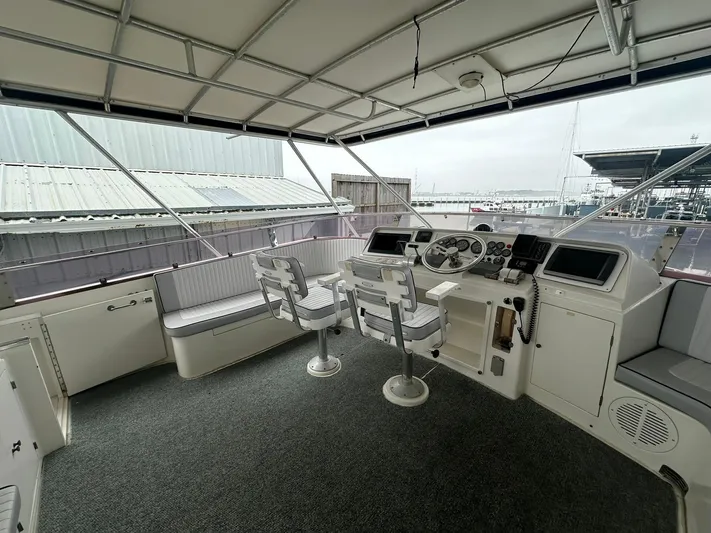 Daddy's Ju-al Yacht Photos Pics 1996 President 655 Flybridge Cockpit MY helm station with seating and navigation controls.