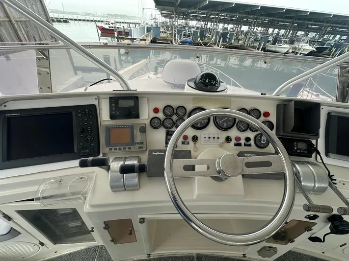 Daddy's Ju-al Yacht Photos Pics 1996 President 655 Flybridge Cockpit MY helm with navigation instruments and steering wheel.