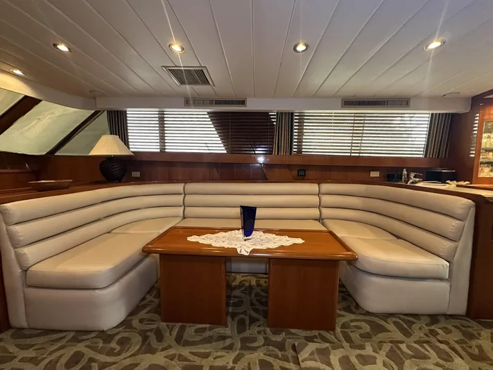 Daddy's Ju-al Yacht Photos Pics Luxurious interior of 1996 President 655 Flybridge Cockpit MY with plush seating and wooden table.