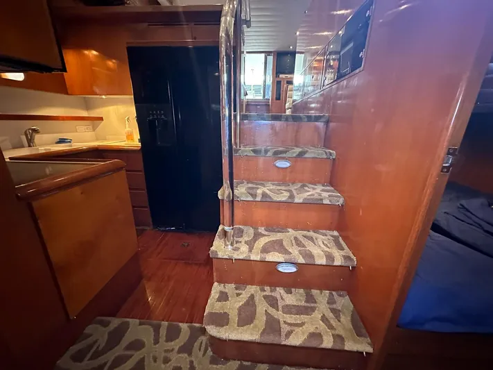 Daddy's Ju-al Yacht Photos Pics Interior of 1996 President 655 Flybridge Cockpit MY yacht with carpeted stairs and kitchen.