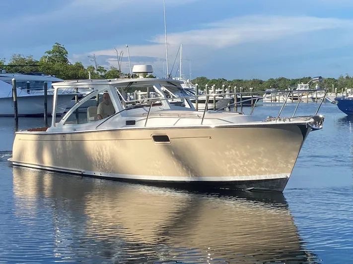 Glory Yacht Photos Pics 2006 MJM 34z Express HT boat on calm water, docked with scenic background.