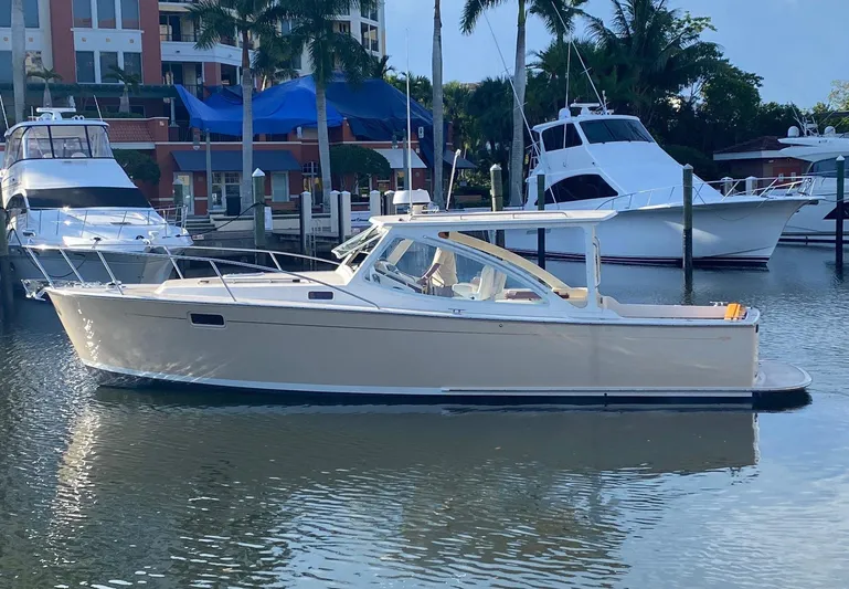 Glory Yacht Photos Pics 2006 MJM 34z Express HT yacht docked in a marina with palm trees.
