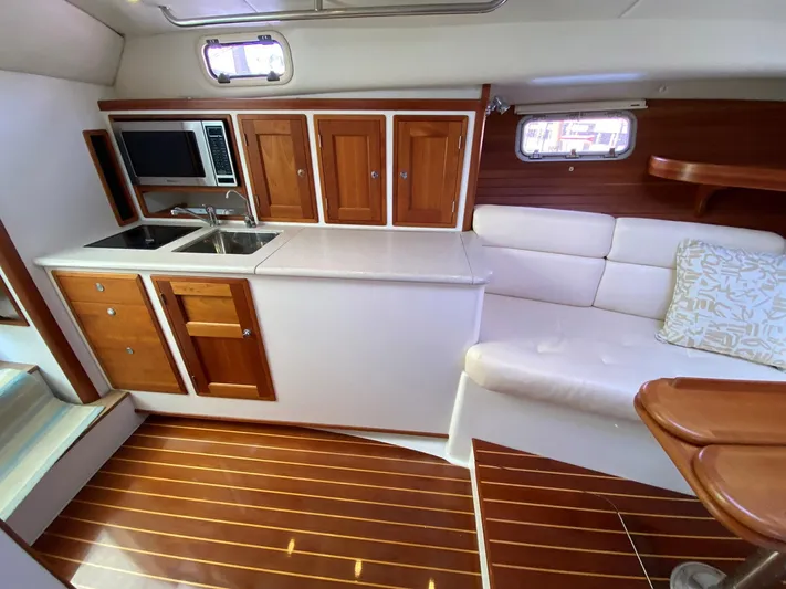 Glory Yacht Photos Pics Interior of 2006 MJM 34z Express HT with kitchenette and seating area.