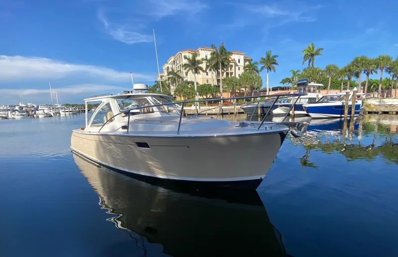 Glory Yacht Photos Pics 2006 MJM 34z Express HT yacht docked in a sunny marina with palm trees.