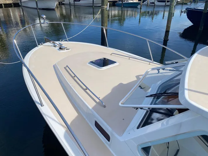 Glory Yacht Photos Pics 2006 MJM 34z Express HT boat deck with railing, docked in marina.