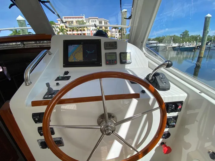 Glory Yacht Photos Pics Helm of 2006 MJM 34z Express HT with wooden steering wheel and navigation equipment.