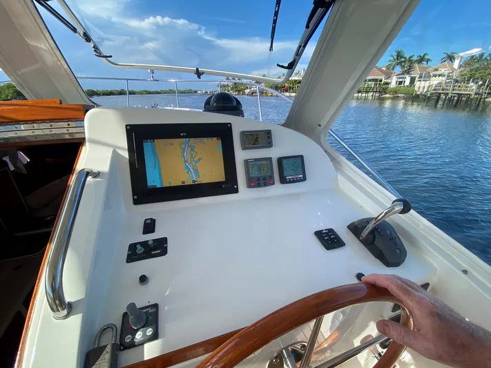 Glory Yacht Photos Pics Helm of 2006 MJM 34z Express HT with navigation display and controls on a sunny day.