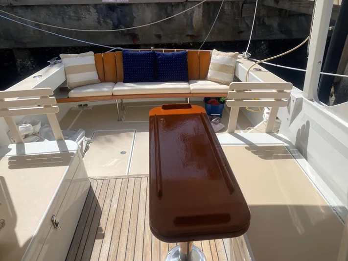 Glory Yacht Photos Pics 2006 MJM 34z Express HT boat interior with cushioned seating and polished wooden table.