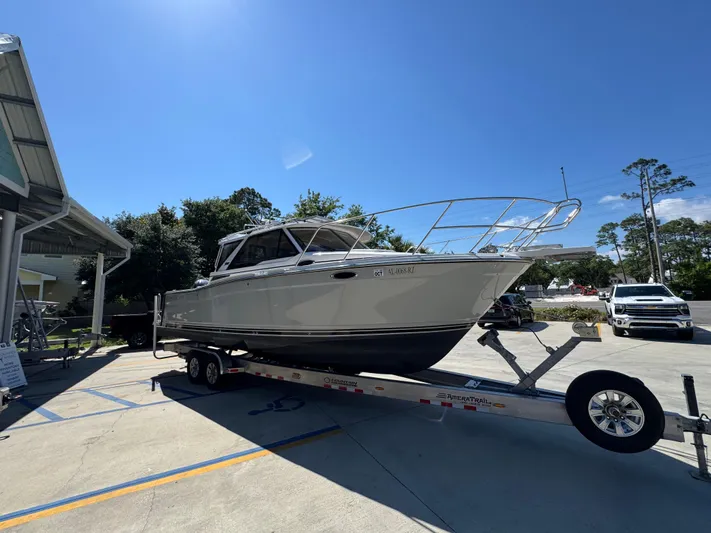  Yacht Photos Pics 2024 Cutwater C-288 Coupe boat on trailer under clear blue sky.