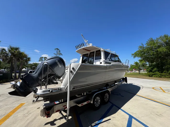  Yacht Photos Pics 2024 Cutwater C-288 Coupe boat on trailer under clear blue sky.