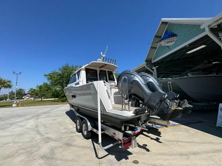  Yacht Photos Pics 2024 Cutwater C-288 Coupe boat on trailer, parked outdoors under clear blue sky.