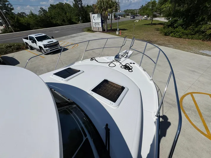  Yacht Photos Pics 2024 Cutwater C-288 Coupe boat deck with hatches, docked near a road.
