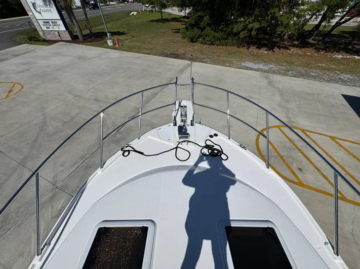  Yacht Photos Pics 2024 Cutwater C-288 Coupe boat deck with shadow and railing in a parking area.