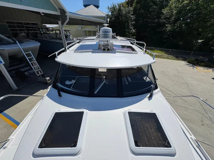  Yacht Photos Pics 2024 Cutwater C-288 Coupe boat with dual sunroofs, docked at a marina.