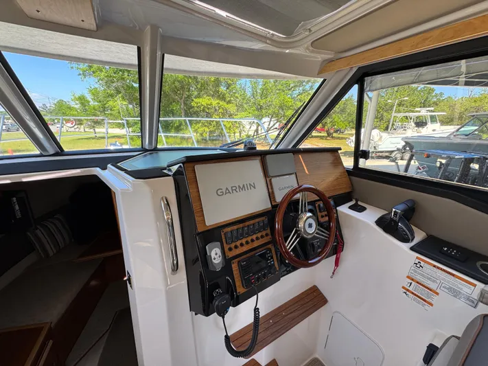  Yacht Photos Pics 2024 Cutwater C-288 Coupe helm with Garmin navigation system and wooden steering wheel.