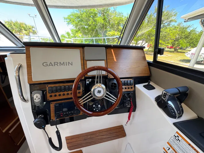  Yacht Photos Pics 2024 Cutwater C-288 Coupe helm with Garmin navigation, wooden accents, and modern controls.