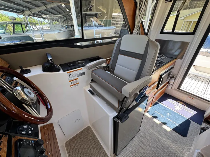  Yacht Photos Pics 2024 Cutwater C-288 Coupe interior with captain's chair and helm, showcasing modern design.