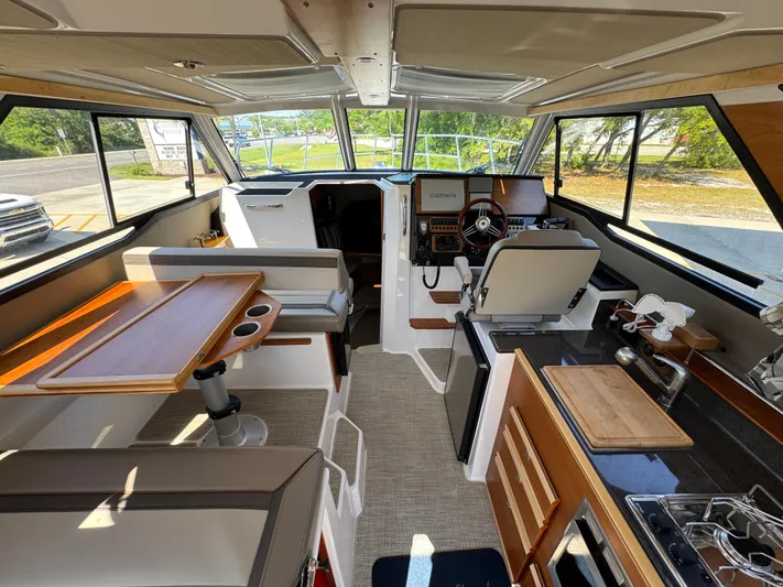  Yacht Photos Pics 2024 Cutwater C-288 Coupe interior with helm, seating, and kitchen area.
