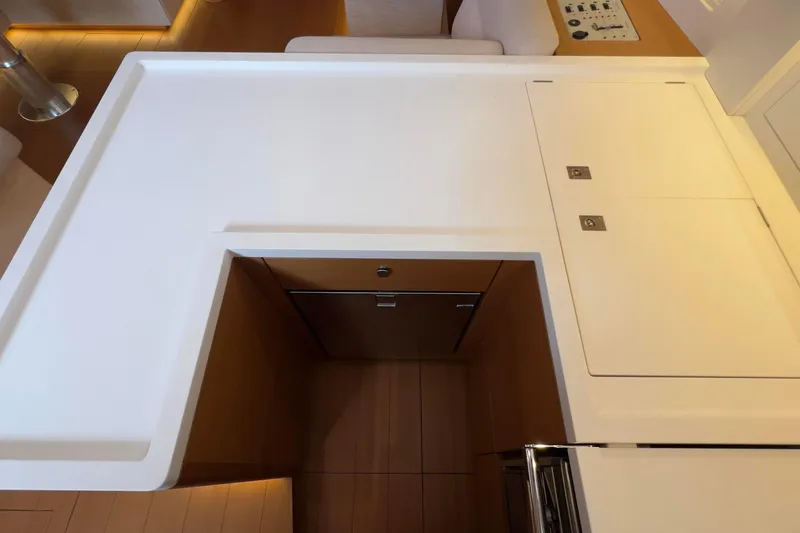  Yacht Photos Pics Modern kitchen area on 2017 Grand Soleil 52 LC yacht, featuring sleek white countertops.