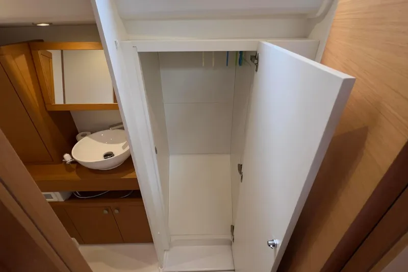  Yacht Photos Pics Interior of 2017 Grand Soleil 52 LC yacht showing bathroom sink and open cabinet.