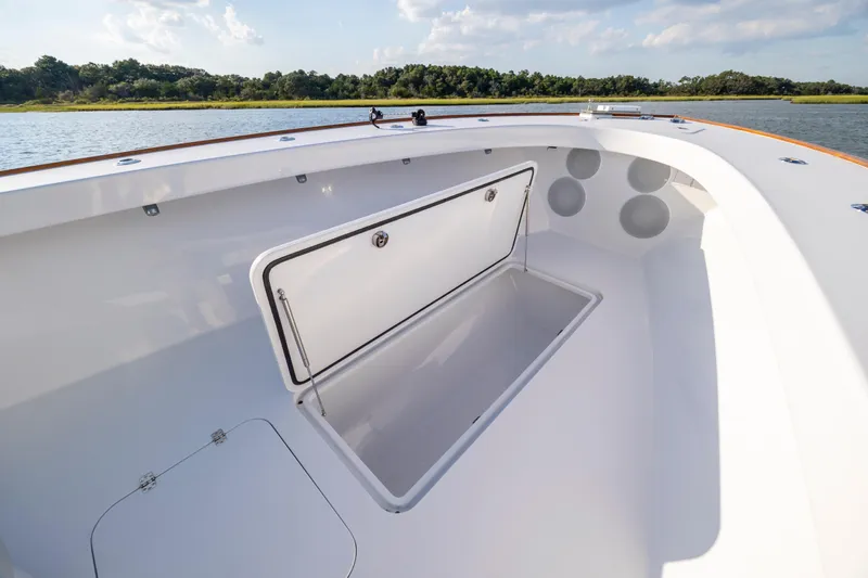  Yacht Photos Pics Open storage compartment on 2018 Tribute 37 boat, with scenic water and forest backdrop.