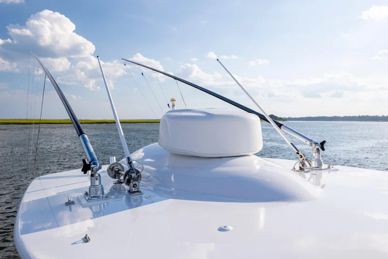  Yacht Photos Pics 2018 Tribute 37 boat with fishing rods on deck, calm water, and blue sky.