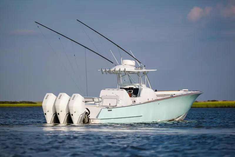  Yacht Photos Pics 2018 Tribute 37 boat with triple outboard engines on calm water.
