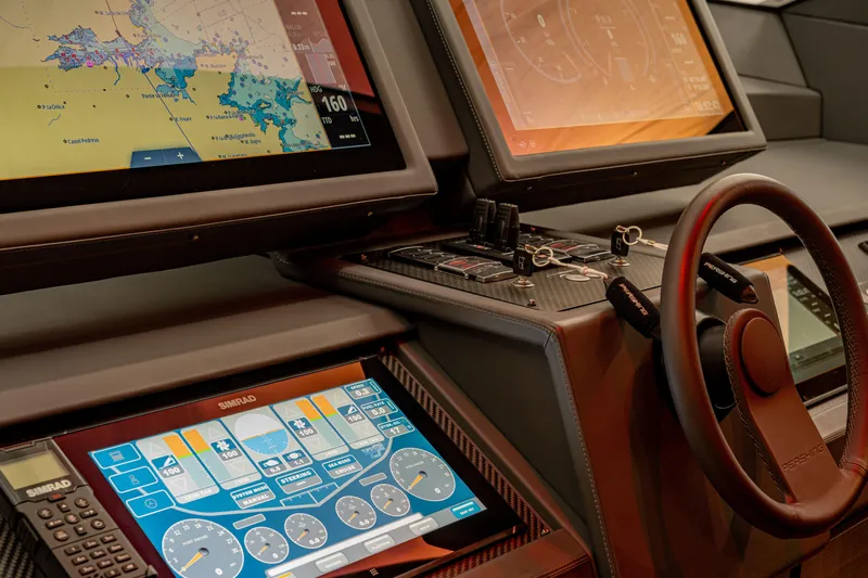Silver Bullet Yacht Photos Pics Control panel of 2022 Pershing 8X yacht with advanced navigation screens and steering wheel.