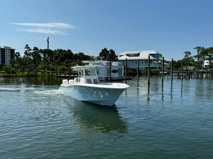  Yacht Photos Pics 2023 Invincible 36 Open Fisherman boat cruising on a calm waterway.