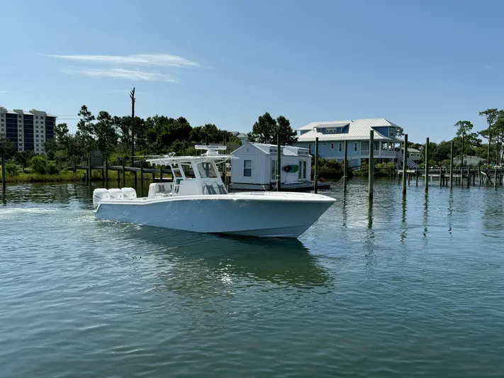  Yacht Photos Pics 2023 Invincible 36 Open Fisherman boat on calm water near docks.